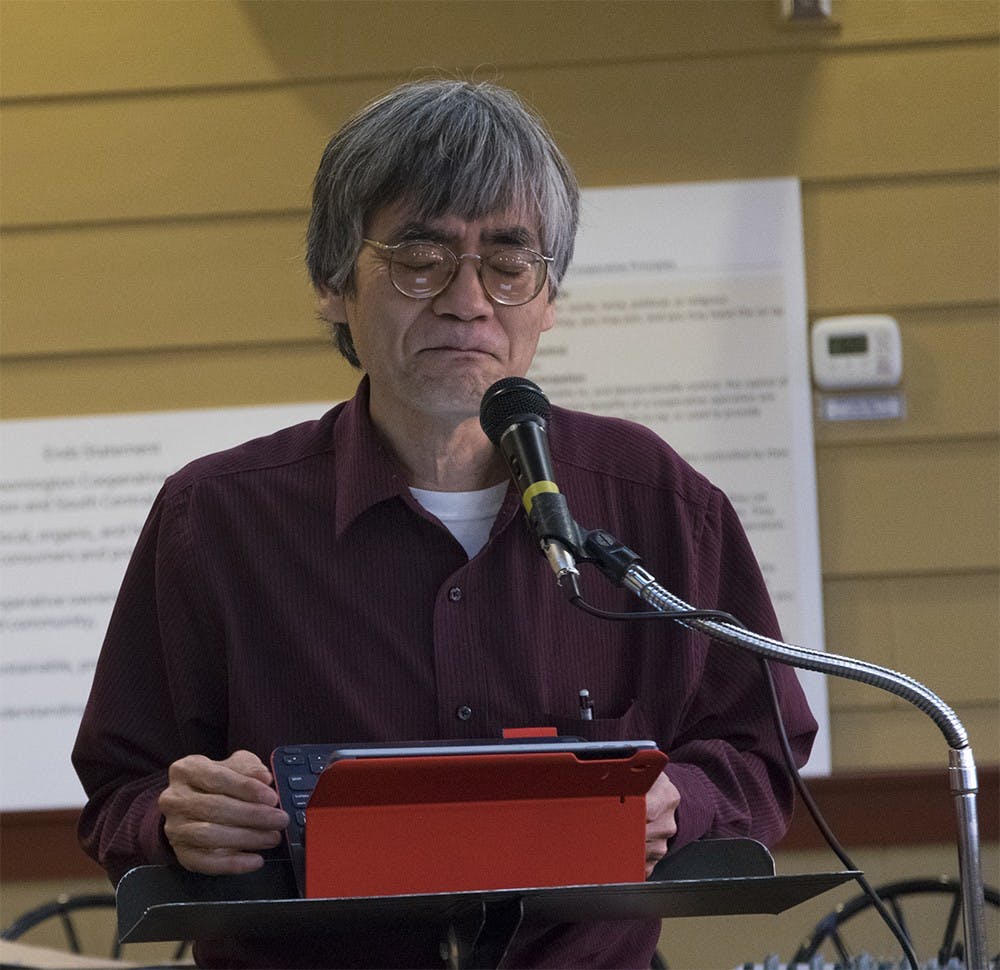 JL Kato, president of Brick Street Poetry and poetry editor of the Filying Island, reads his poem named "Ghost Songs" during a poetry reading event at Bloomingfoods. "Ghost Songs" was inspired from a song that Kato's mother used to sing. 