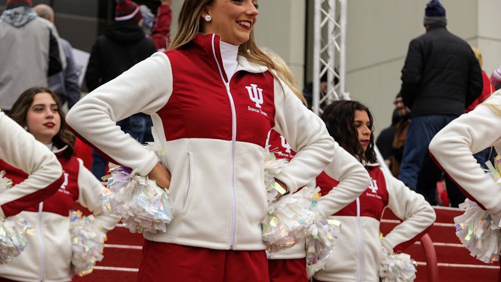 Senior Redstepper Julia Amones smiles at the crowd during the Walk, a tradition where the Marching Hundred and cheerleaders perform as the football team walks to Memorial Stadium, on Nov. 13, 2021, outside Assembly Hall. Amones said she loves her teammates and can't wait to watch and cheer them on once she graduates. 