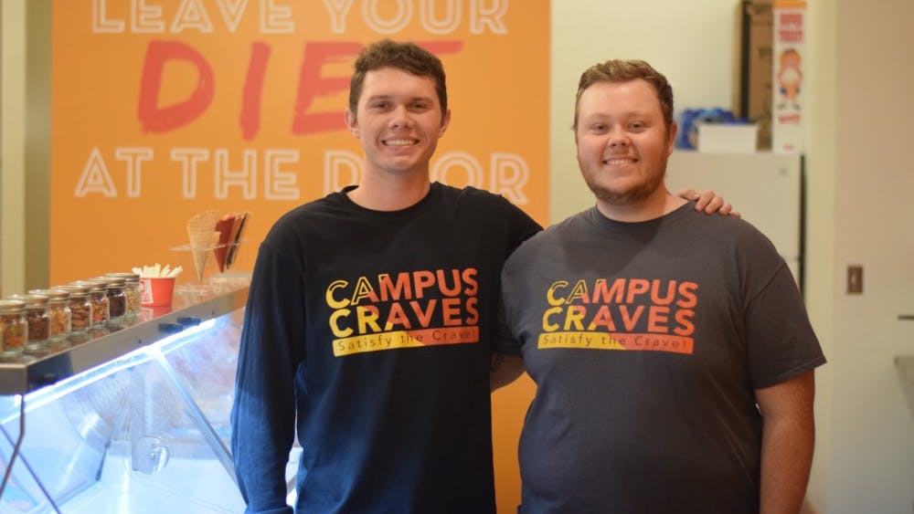 Campus Craves founders Brayden Sammons and Hunter Haines pose behind the counter. The two of them started planning the store their senior year of high school.
