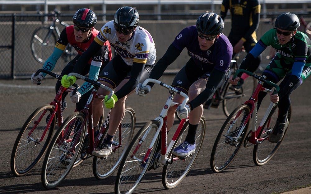 From left to right, Luke Tormoehlen of Delta tau Delta, Andrew and Joe Krahulik of Sigma Alpha Epsilon and Riley Figg of Wright Cycling ride through the first turn at Bill Armstrong Stadium during Miss N Out on Saturday. Joe Krahulik placed first for the men's race, followed closely by his brother Andrew.