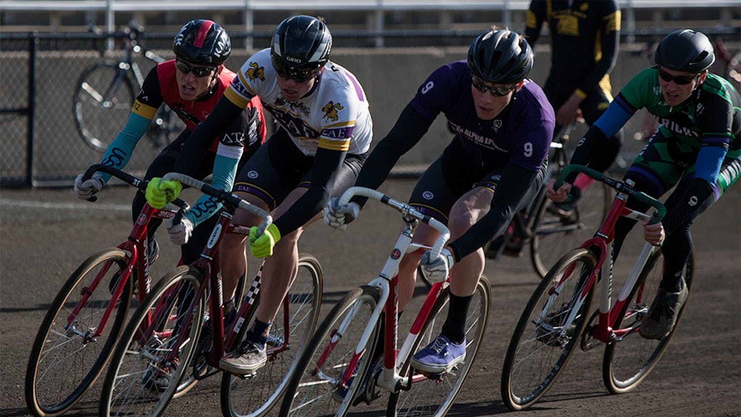 From left to right, Luke Tormoehlen of Delta tau Delta, Andrew and Joe Krahulik of Sigma Alpha Epsilon and Riley Figg of Wright Cycling ride through the first turn at Bill Armstrong Stadium during Miss N Out on Saturday. Joe Krahulik placed first for the men's race, followed closely by his brother Andrew.