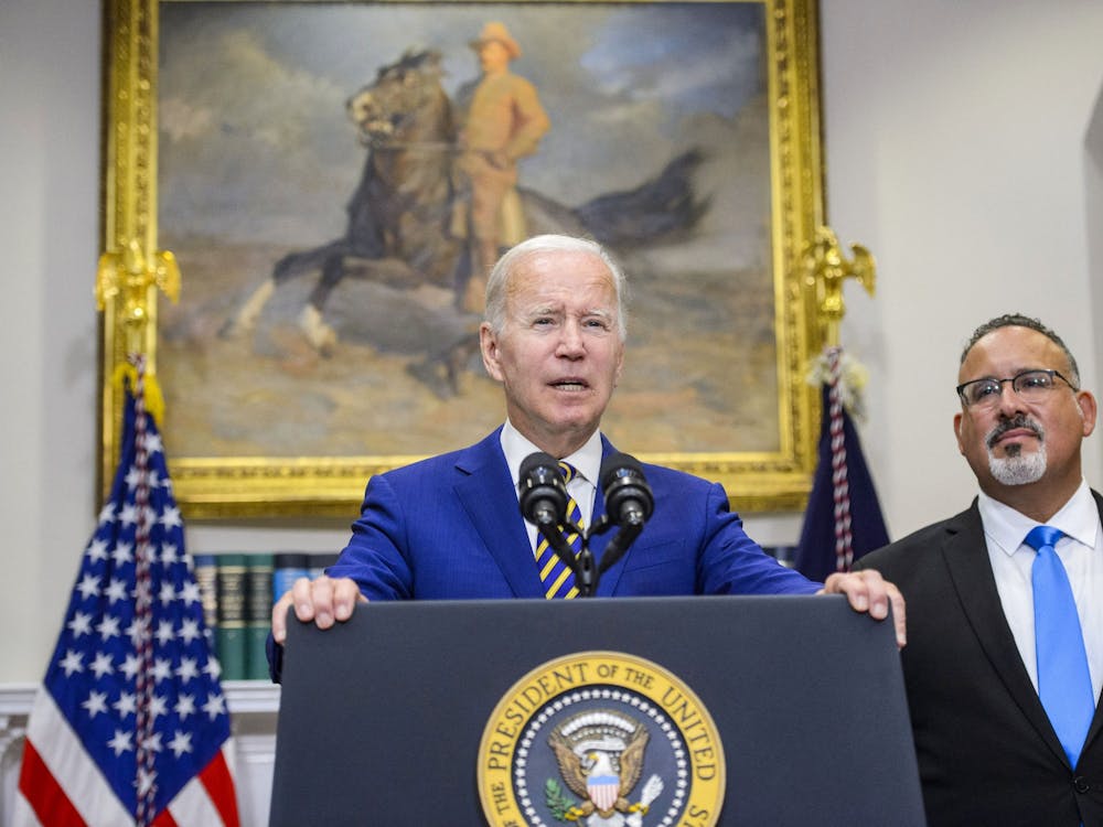 President Joe Biden speaks as Secretary of Education Miguel Cardona looks on after Biden announced a federal student loan relief plan Aug. 24, 2022, in the Roosevelt Room at the White House. 