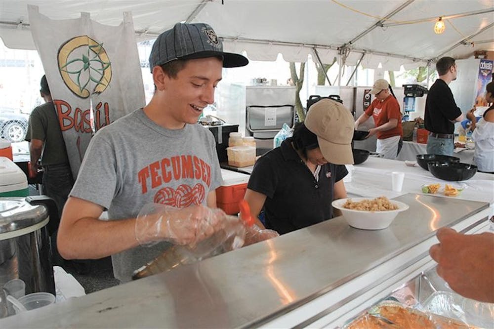 IU junior Andy McAlister serves customers at the Basil Leaf booth during Taste of Bloomington on June 21, 2008, at Showers Plaza.