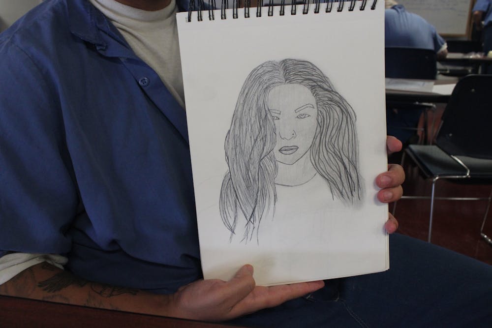 <p>Russell H. holds this portrait of the woman he calls “Mother Nature” on April 4, 2023, in the Indiana University Prison Arts Initiative class at the Putnamville Correctional Facility. IUPAI incorporates drawing and writing components for the inmates.</p>