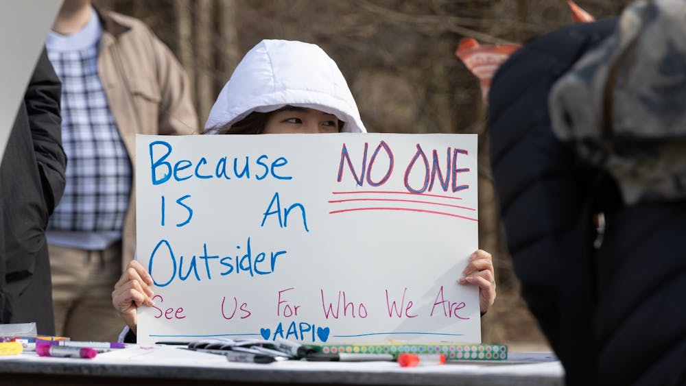 Juli Thach displays her sign at the AAPI rally on Feb. 4, 2023, in Dunn Meadow. She helped run a table at the event which allowed for those in attendence to create their own signs expressing solidarity with the AAPI community.