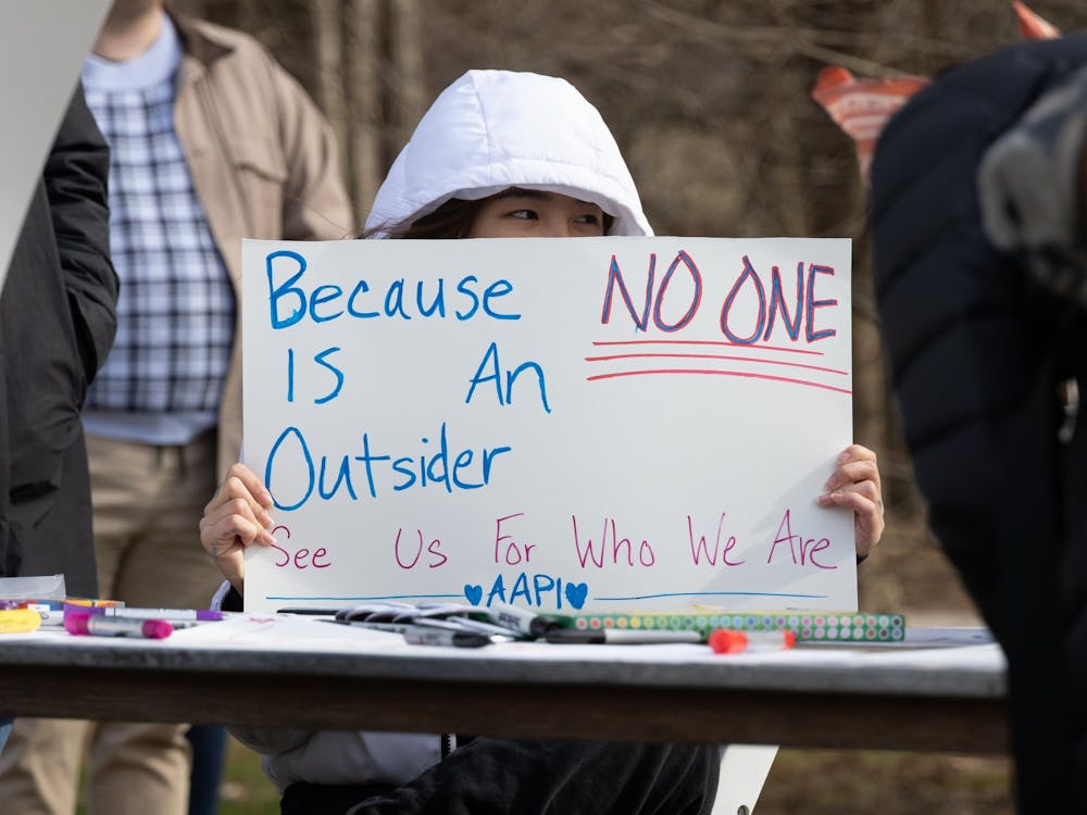 Juli Thach displays her sign at the AAPI rally on Feb. 4, 2023, in Dunn Meadow. She helped run a table at the event which allowed for those in attendence to create their own signs expressing solidarity with the AAPI community.