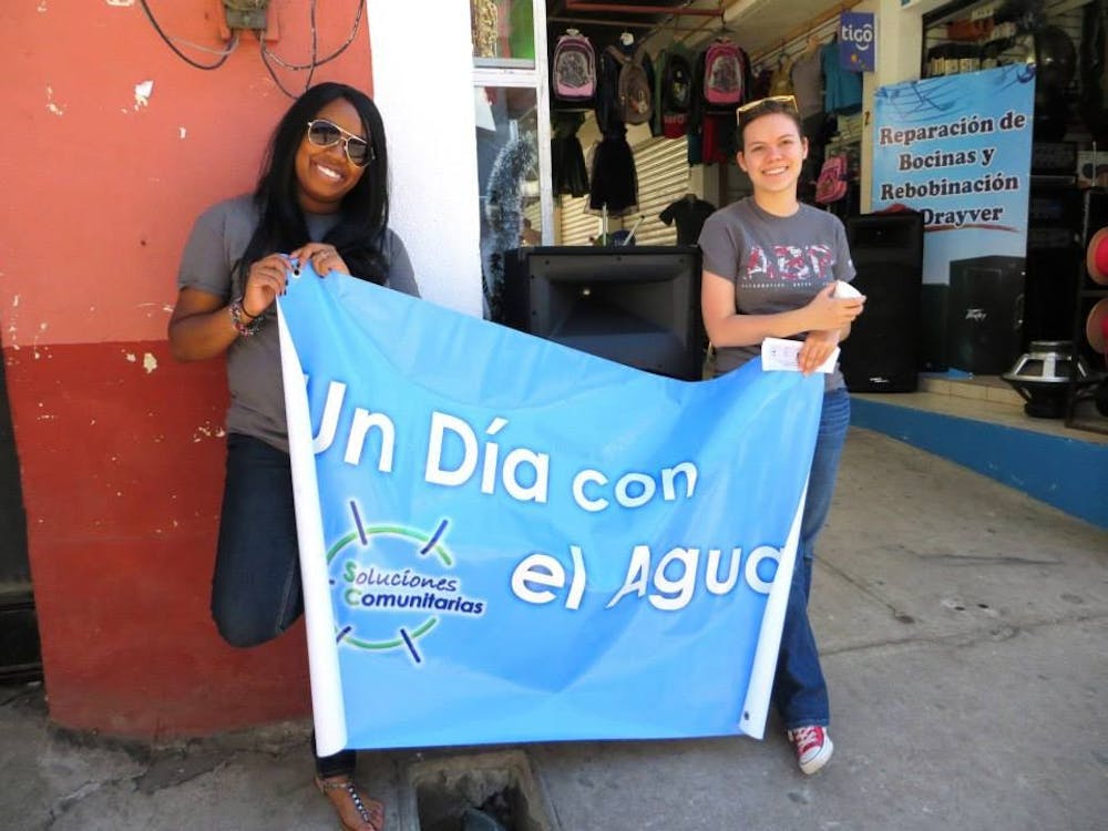 Briana Terrell and Laura Lueken hold up a banner in Guatemala during an alternative spring break trip.