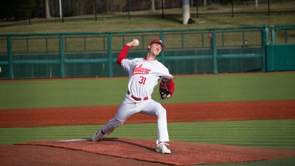 Freshman right-handed pitcher Evan Whiteaker throws a pitch February 22, 2023 against Miami (Ohio) at Bart Kaufman Field in Bloomington, Indiana. Whiteaker threw just over four innings, not allowing an earned run, in Indiana&#x27;s 4-3 victory over Illinois in the Big Ten Tournament May 23. 