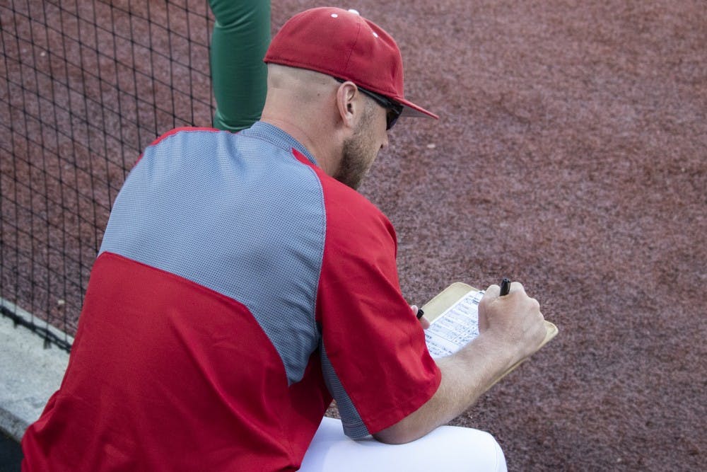 <p>Head coach Jeff Mercer writes on his batting order list May 14 at Bart Kaufman Field. IU played the University of Louisville and lost, 8-7.</p>