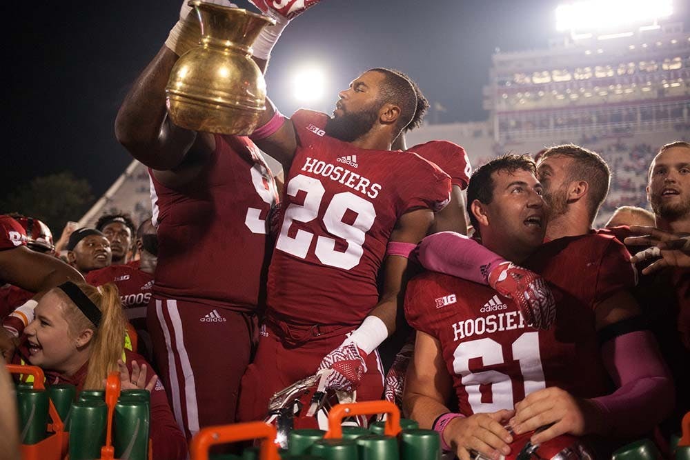 Seniors Ralph Green III, left, and Dawson Fletcher hold the Brass Spitoon in celebration after beating Michigan State in overtime 24-21 Saturday night.