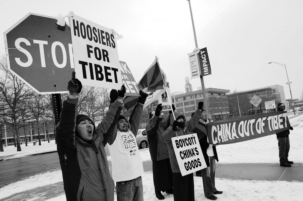 A group of protesters hold up signs and shout outside the building where Zhou Wenzhong, Chinese Ambassador to the U.S., was speaking in Indianapolis, Friday. Wenzhong told an audience his country backs a “peaceful development” strategy throughout the world, but he also chided the U.S. for protectionist trade sentiment and said Taiwanese independence is out of the question. 