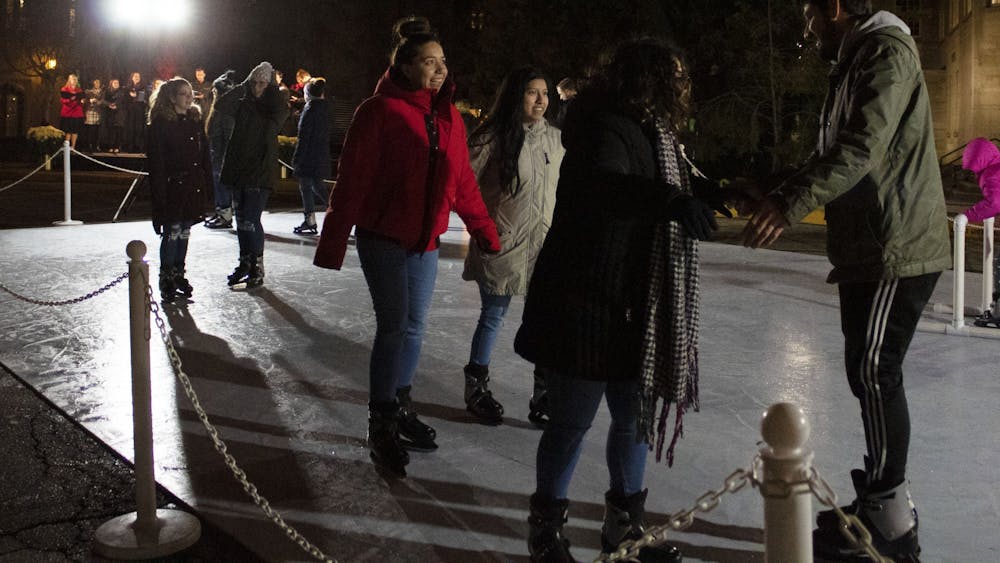 Event attendees skate on an ice rink Dec. 2 in front of the Indiana Memorial Union. The event also included hot chocolate, capella performances and a countdown to light the IMU candle display on the side of the building.