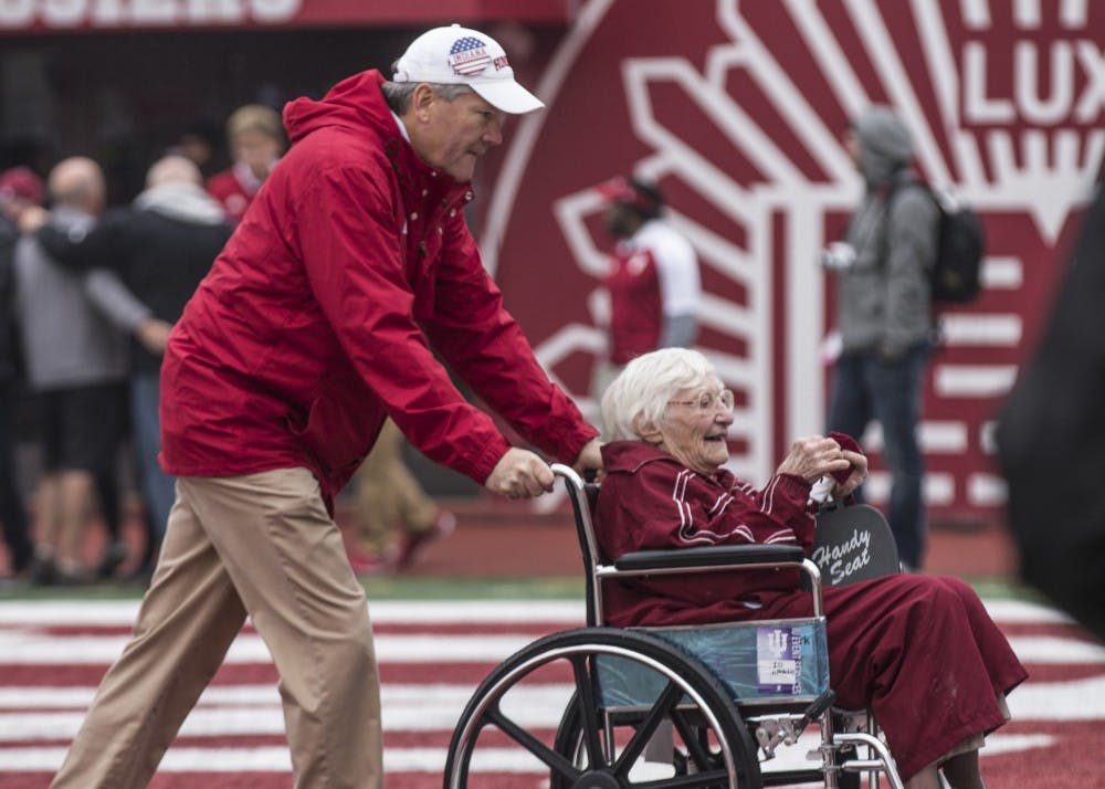 <p>IU Athletics Director Fred Glass wheels the oldest member of 50 Year Varsity Club Donors off the field after an on-field recognition ceremony at the game against Wisconsin on Nov. 4. Glass was appointed athletics director in 2009.</p>