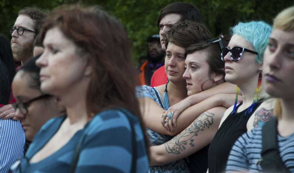 Victoria Brown, left, and Lily Regina comfort each other during the vigil on Tuesday evening at the Bloomington City Hall.