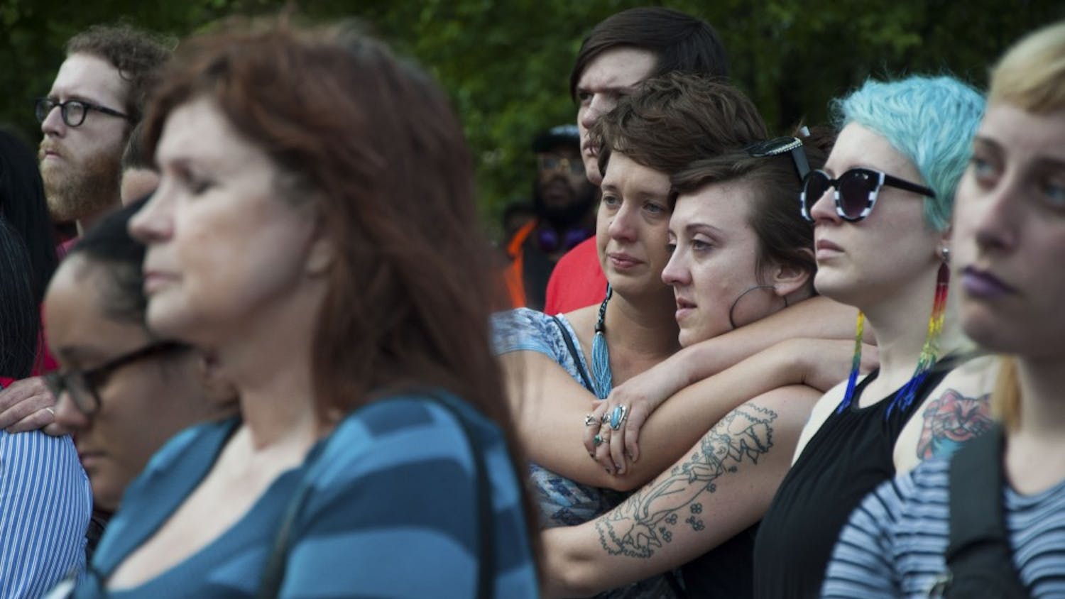 Victoria Brown, left, and Lily Regina comfort each other during the vigil on Tuesday evening at the Bloomington City Hall.