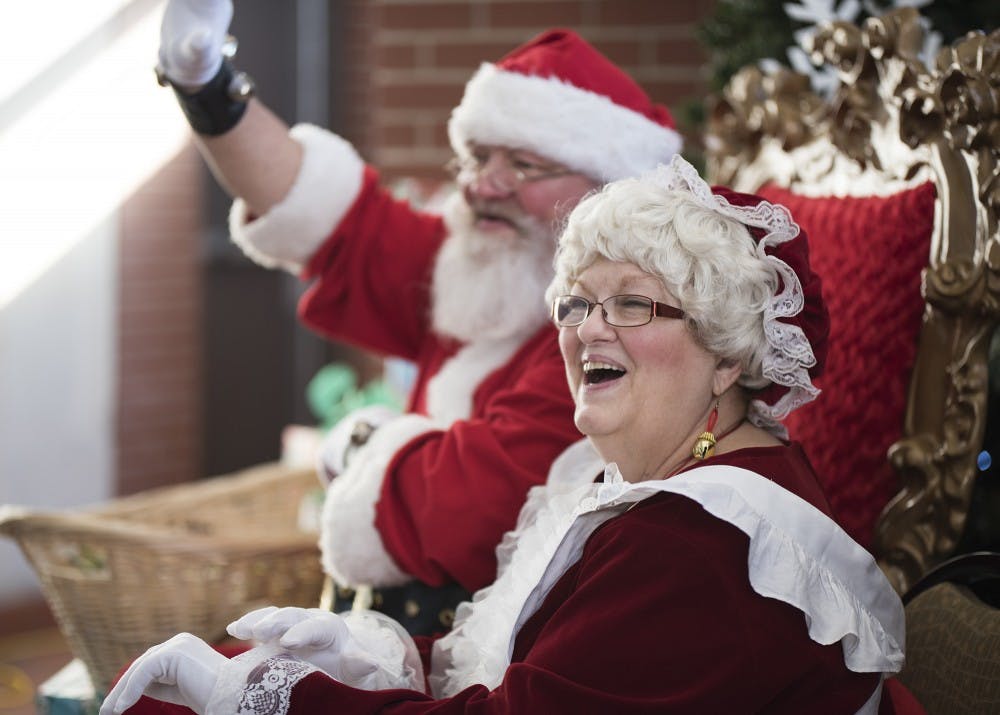 Jamie Aker and her husband Mark say hello to children coming to visit them Friday at the Fountain Square Mall. The couple has been playing Mr. and Mrs. Claus for about seven years.