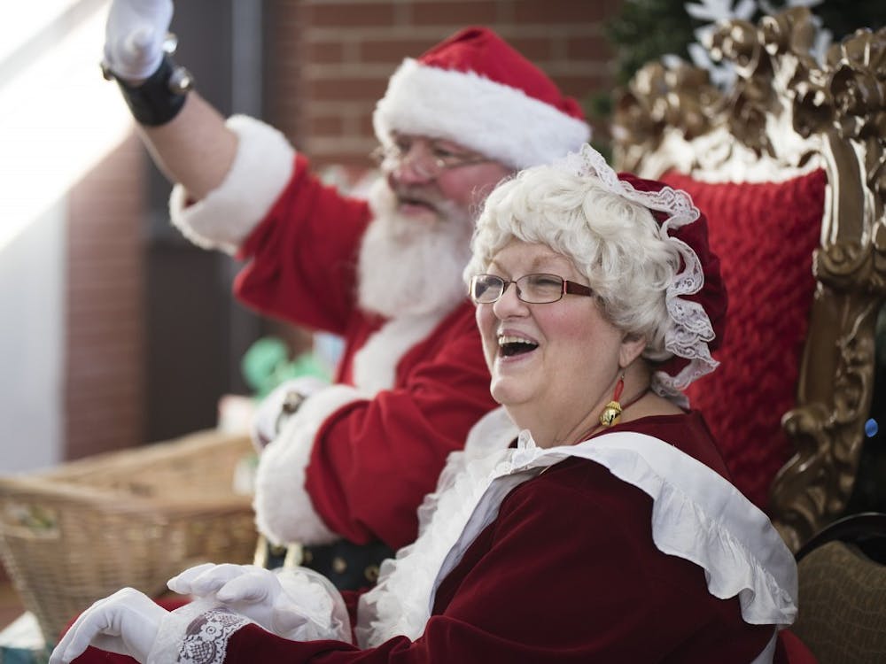 Jamie Aker and her husband Mark say hello to children coming to visit them Friday at the Fountain Square Mall. The couple has been playing Mr. and Mrs. Claus for about seven years.