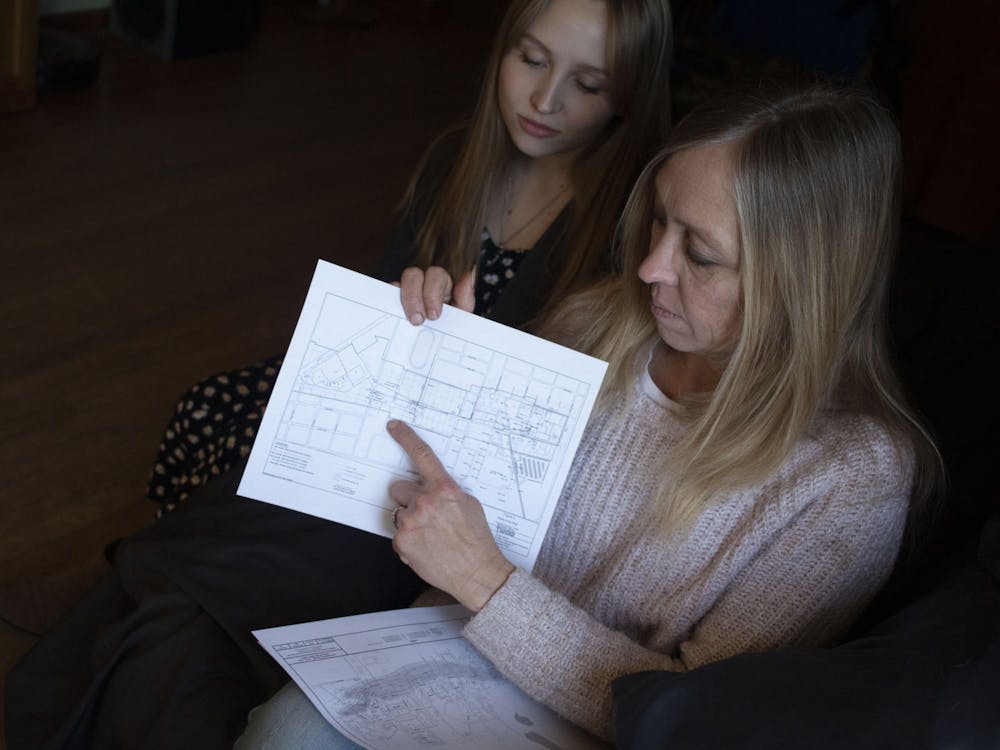 Debbie Corcoran和她的女儿悉尼芦苇看了于印第安纳Martinsville的家中的化学羽毛地图。化学羽毛是由来自城市不同公司的不正确的化学品制成的受污染区域。其中一个人经历了他们的邻居。