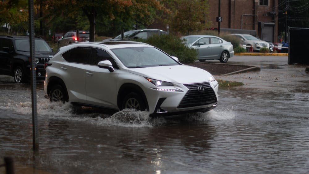 A car drives through water on the corner of Indiana Avenue and 6th Street on Sept. 26, 2023 in Bloomington. Areas in central Indiana are expected to experience scattered thunderstorms and some flooding Sept. 26, 2023.