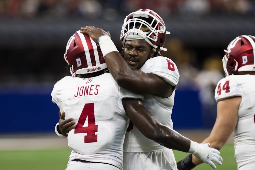 <p>Then-junior defensive back Marcelino Ball hugs then-sophomore linebacker Cam Jones on Aug. 31 at Lucas Oil Stadium in Indianapolis. </p>