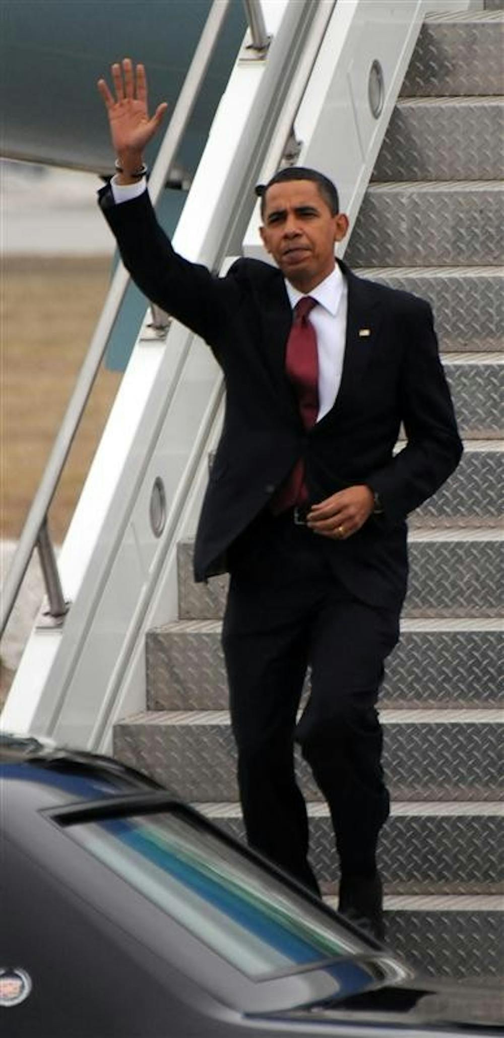 President Barack Obama waves as he steps off Air Force One upon his arrival in South Bend, Ind.