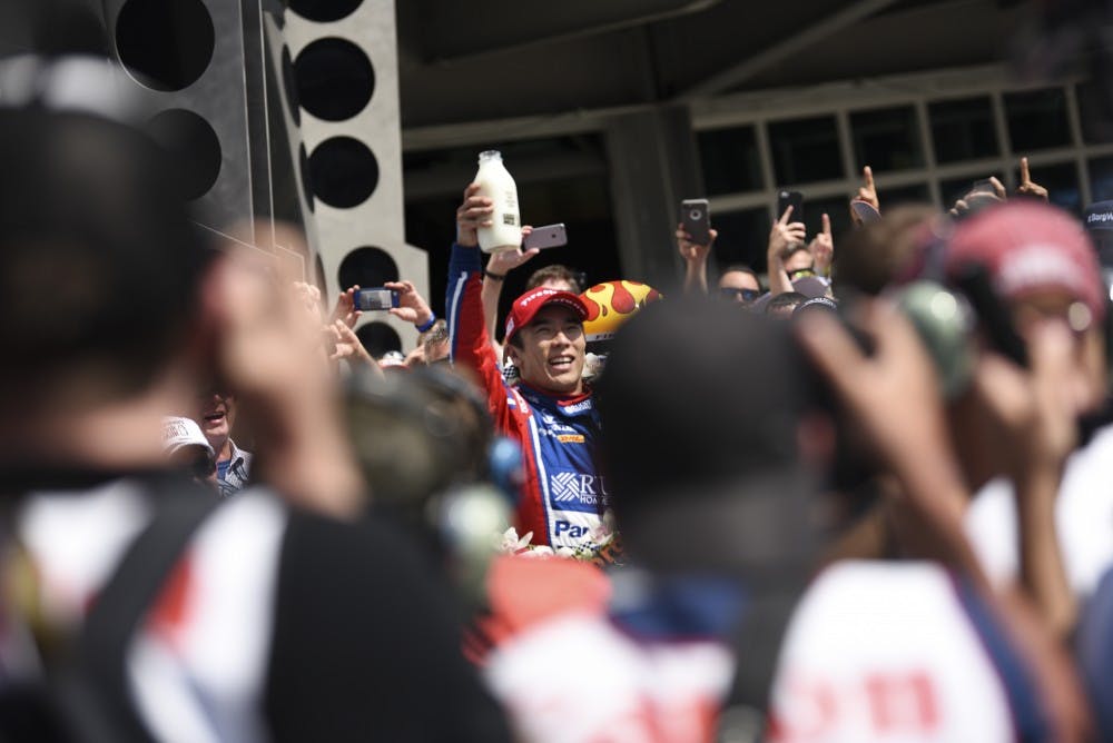 Takuma Sato holds up the ceremonial milk after winning the Indianapolis 500. Sato is a Japanese driver that races for Andretti Autosports. 