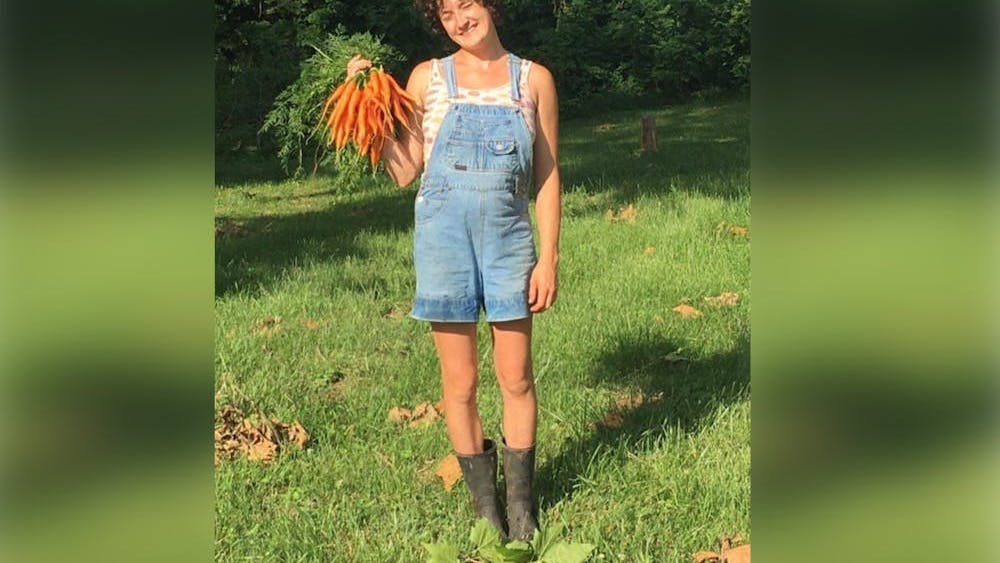 Bloomington Activist Maggie Gates poses with carrots while working at Common Home Farm in summer 2021. More than 60 people, including Gates, have been indicted on charges of racketeering connected to their protest movement opposing construction of the Atlanta Public Safety Training Center, commonly referred to as “Cop City,” in Atlanta, Georgia.