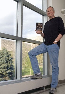 Telecommunications Professor Lee Sheldon holds a copy of one of the newest games he designed, "Agatha Christie: Murder on the Orient Express," at the Radio-Televison center Thursday night.