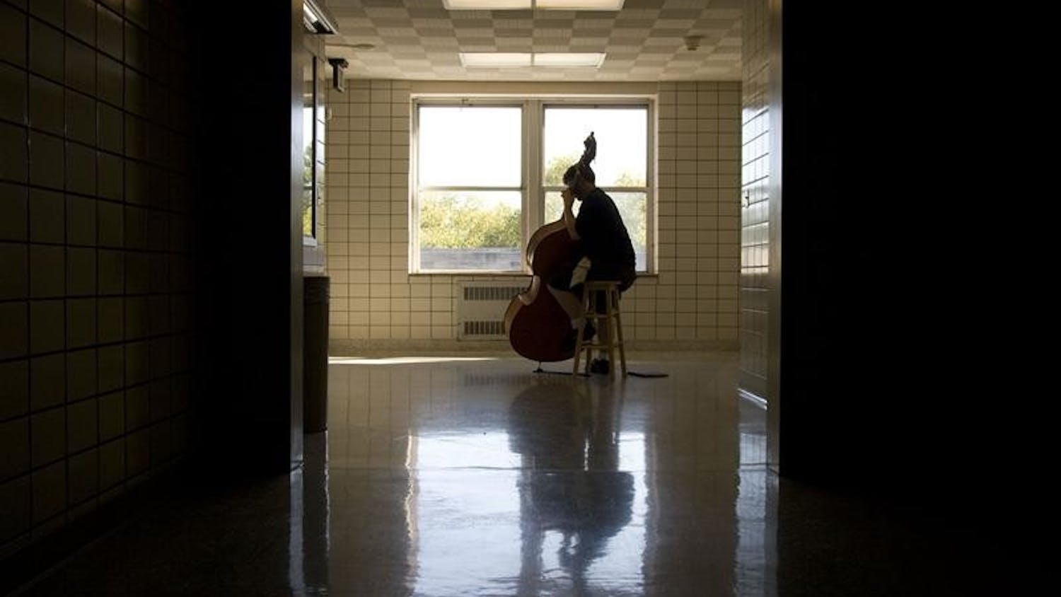 Graduate student Noah Reitman practices his double bass, which is one octave lower than a cello, Wednesday in the Jacobs School of Music.  Reitman's double bass was made in Mirecourt, France 150 years ago.  
