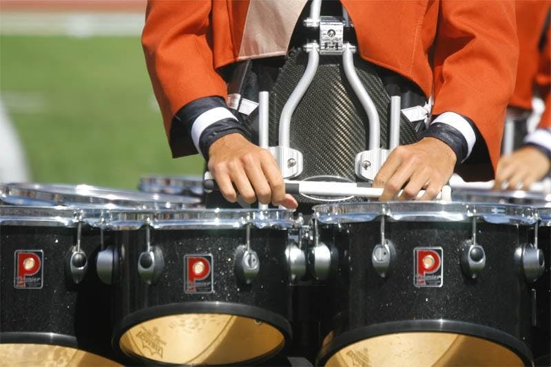 A tenor drum player for the Mandarins pauses between songs during the corps' DCI Quarterfinals performance Thursday afternoon at Memorial Stadium.