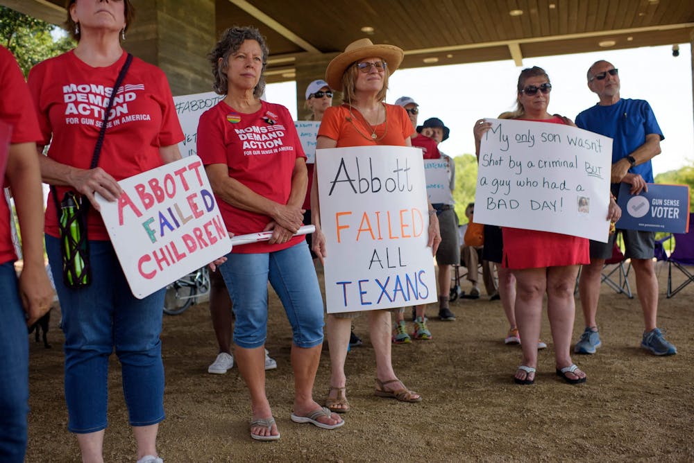 <p>People hold signs during a &quot;Moms Demand Action&quot; protest June 17, 2021, at Buffalo Bayou Park in Houston after a new Texas gun law signed by Gov. Greg Abbott which allows Texans to carry firearms in public without a permit. </p>