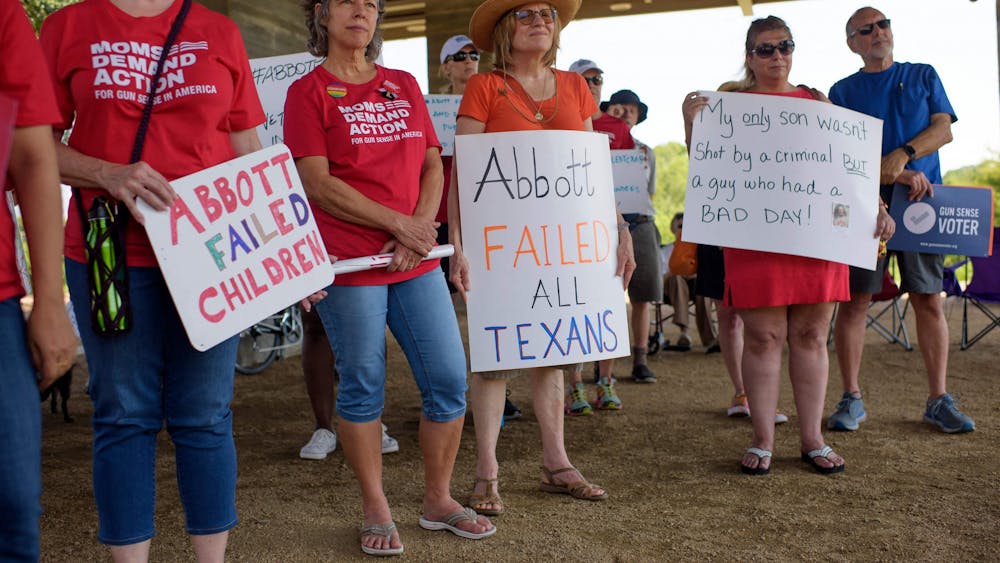 People hold signs during a &quot;Moms Demand Action&quot; protest June 17, 2021, at Buffalo Bayou Park in Houston after a new Texas gun law signed by Gov. Greg Abbott which allows Texans to carry firearms in public without a permit. 