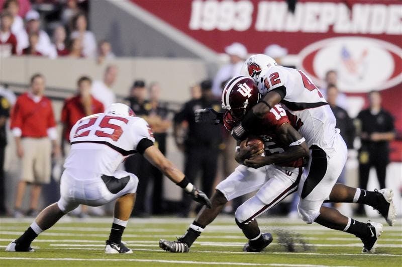 IU quarterback Kellen Lewis is tackled after a short run by Ball State's Sean Baker, No. 25, and Davyd Jones, No. 42, on Saturday night at Memorial Stadium. Ball State defeated IU 42-20.