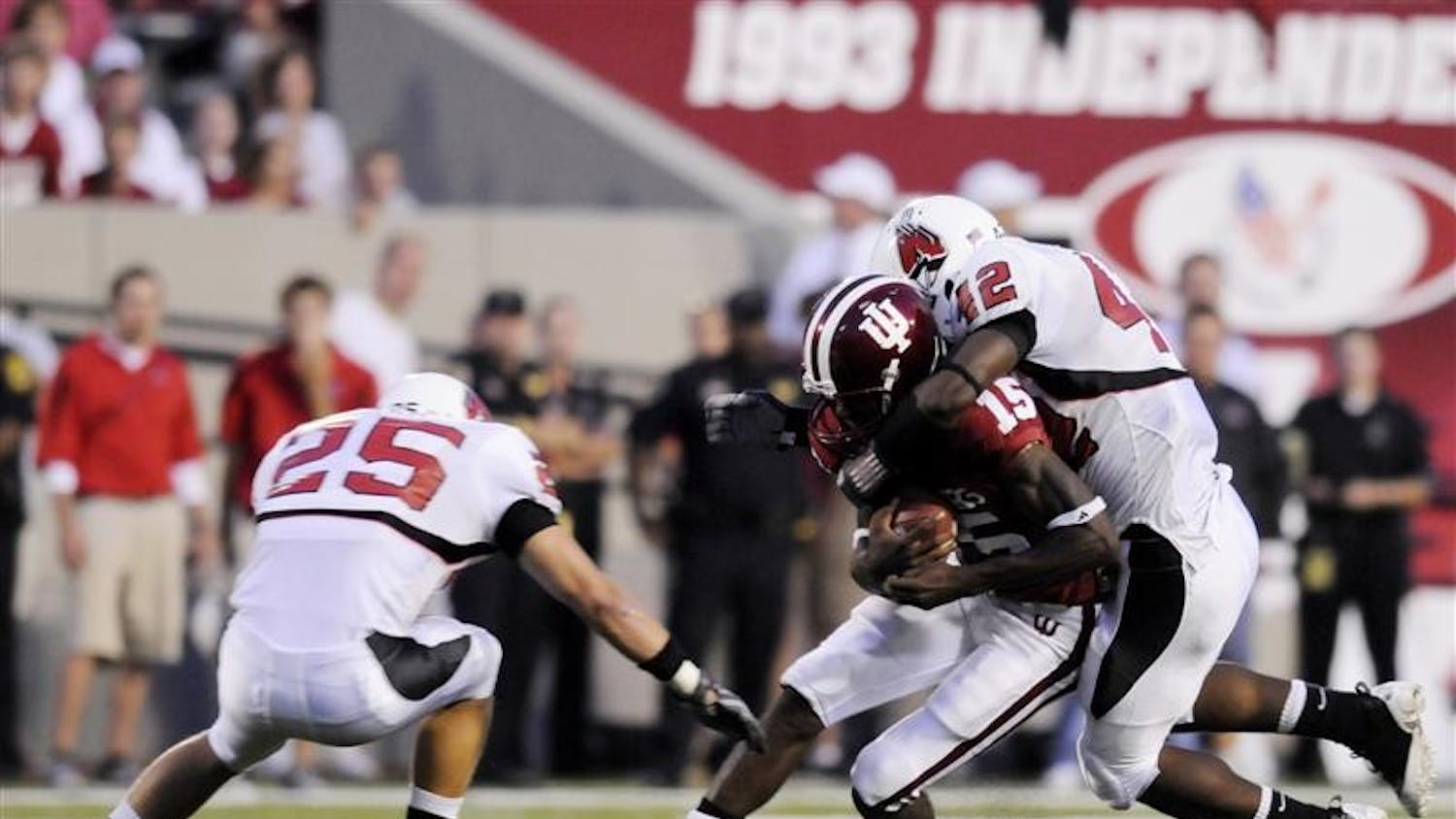 IU quarterback Kellen Lewis is tackled after a short run by Ball State's Sean Baker, No. 25, and Davyd Jones, No. 42, on Saturday night at Memorial Stadium. Ball State defeated IU 42-20.