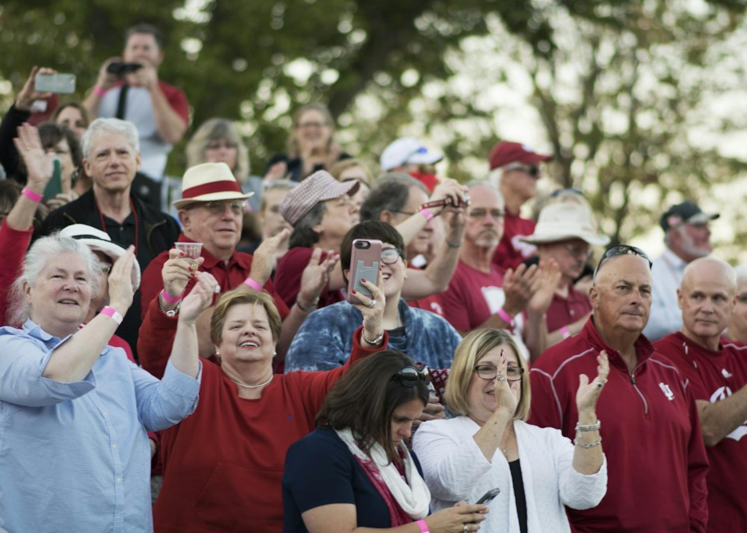 Parade spectators cheer as the Marching Hundred perform at the intersection of 17th Street and Woodlawn Avenue on Friday evening as part of the homecoming parade. The parade started at the Indiana Memorial Union and worked its way north to the tailgating fields.&nbsp;