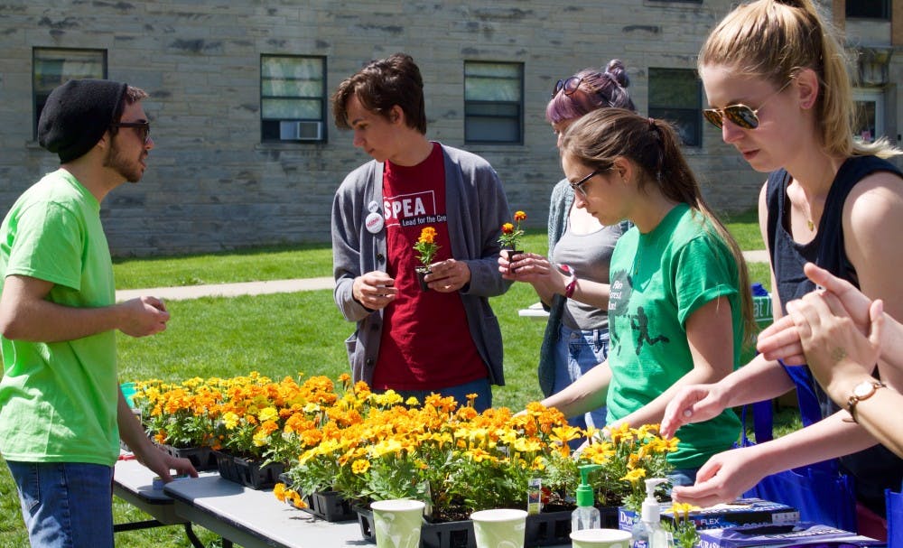 Participants exchange litter for flowers during "Flower Power" on Saturday at Wright Quad. 