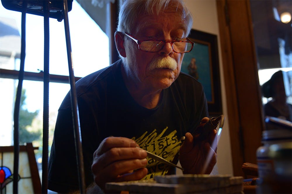 Local jewelry designer Tim Terry melts pieces and molds them to the base of the ring's center setting during an event hosted at The Venue to demonstrate how to make homemade jewelry  on Tuesday evening.