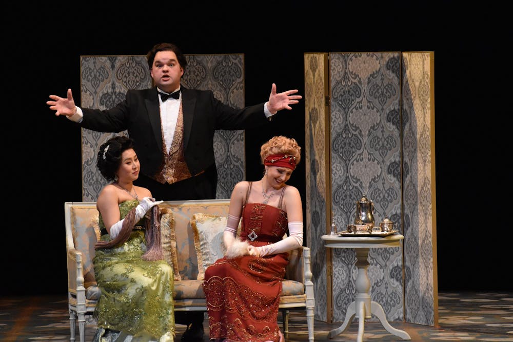 <p>Yue Yin, left, and Kayla Kramer, right, react to Cody Boling, middle, in &quot;La Rondine.&quot; The opera was written by Giacomo Puccini in 1917 and follows Parisian courtesan Magda and her lover Ruggero. </p>