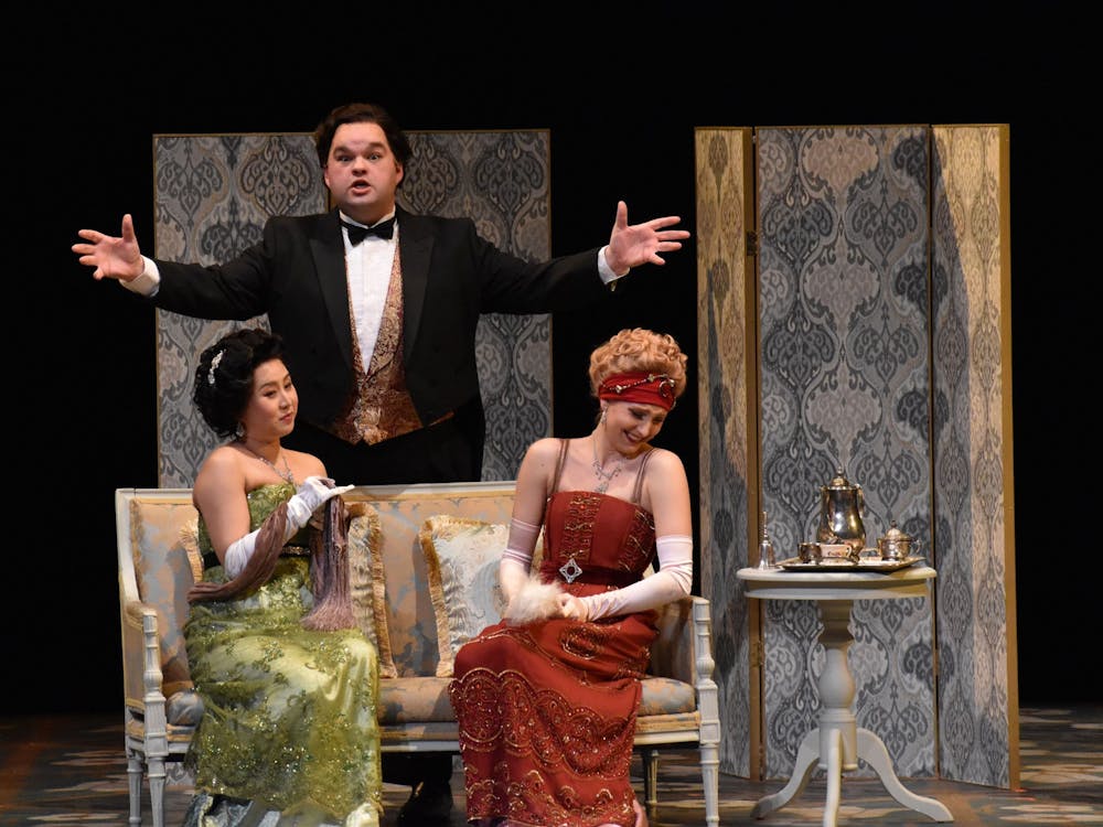 Yue Yin, left, and Kayla Kramer, right, react to Cody Boling, middle, in &quot;La Rondine.&quot; The opera was written by Giacomo Puccini in 1917 and follows Parisian courtesan Magda and her lover Ruggero. 
