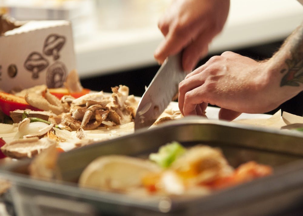同一个世界餐饮公司的行政总厨柯尔宾·莫威克为一顿饭准备蘑菇。在假期里少吃些开胃菜，用更健康的食物来平衡丰富的食物选择，是可以吃得健康的。