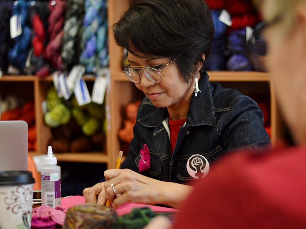 Mary Ann Gingles, the owner of Yarns Unlimited, traces the felt backs for Pussyhat pins Wednesday in her shop. Gingles invited women from around the community to gather at Yarns Unlimited&nbsp;for International Women’s Day and A Day Without a Woman.