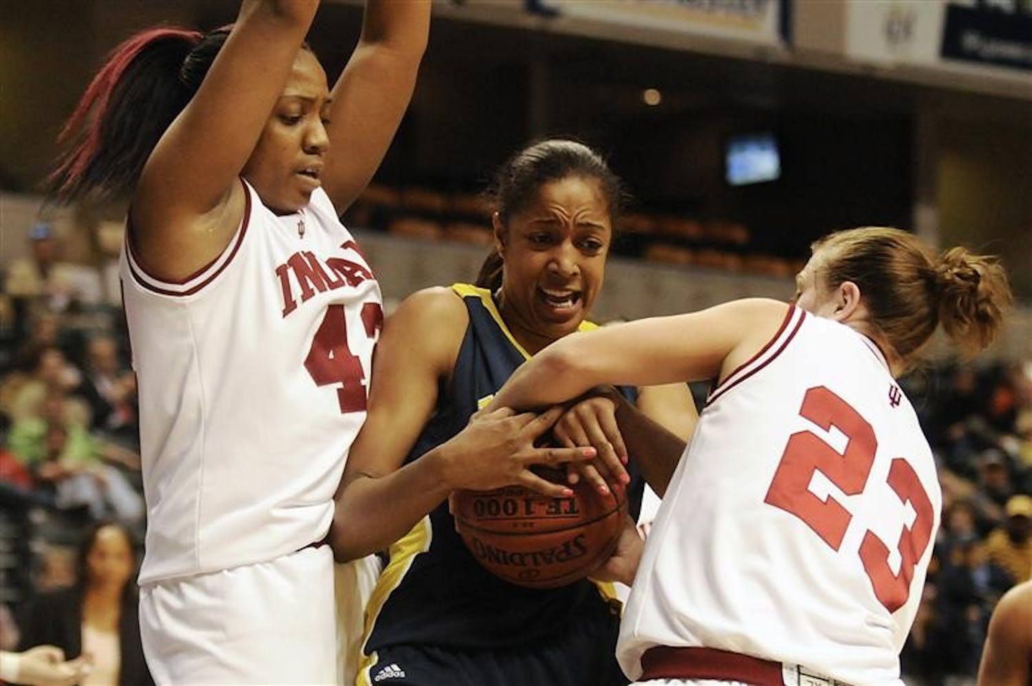 IU forward Amber Jackson, left, and guard Jamie Braun, right, try to strip the ball away from Michigan's Stephany Skrba during the first round of the Big Ten Woman's Tournament on Thursday at Conseco Fieldhouse in Indianapolis. IU trailed 28-26 at the half.
