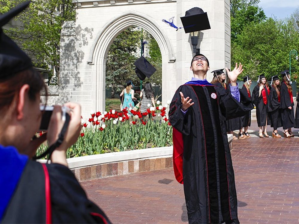 Graduates take pictures at the Sample Gate on May 10, 2014. 