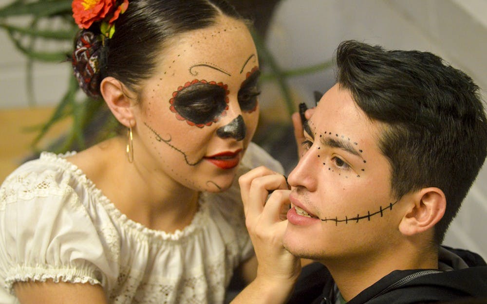 Sophomore Gabi Steenberger does face paint for IU students and Bloomington residents during the Dia de los Muertos event Wednesday evening in La Casa.