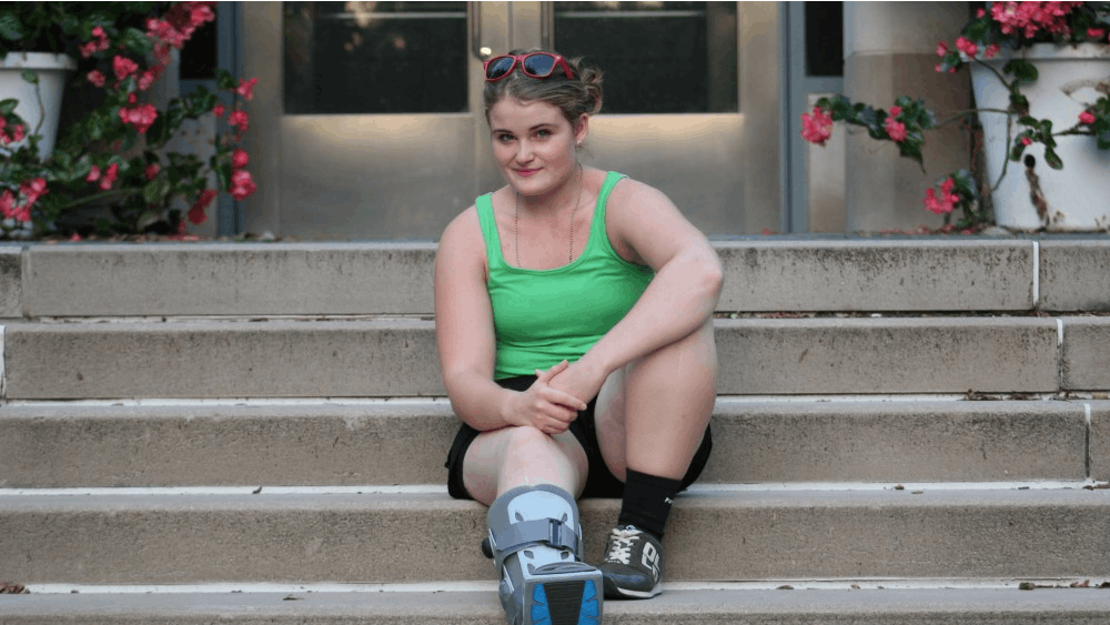 Deborah Alix, a senior majoring in theatre and drama, rests her fractured foot Aug. 28 on the steps outside the Neal-Marshall Black Culture Center. Her doctor believes she should be out of the boot by October.
&nbsp;
