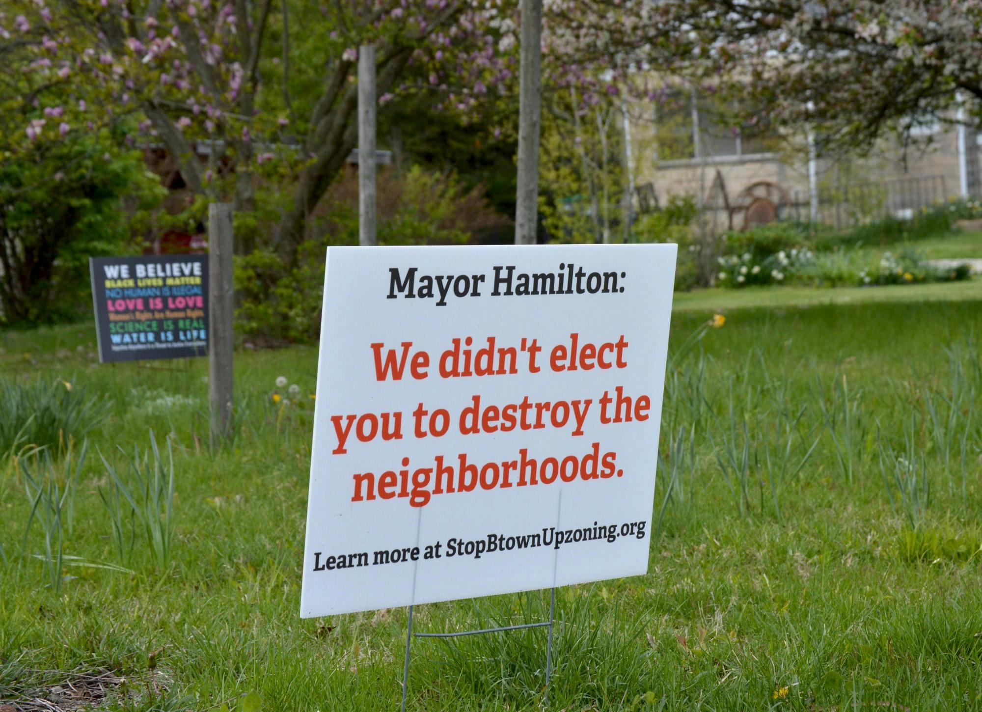 布莱恩公园(Bryan Park)附近的一块牌子上写着“汉密尔顿市长:我们不是选你来摧毁社区的。”“一个拟议的分区区域将允许在传统的独栋住宅社区建造复式住宅和类似的结构。”