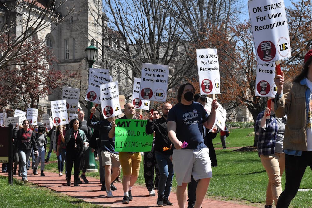 <p>Strikers march in front of Franklin Hall April 13, 2022, during the grad worker strike. IU is reducing the number of future doctoral student admissions to account for the increased stipend for graduate worker wages.</p>