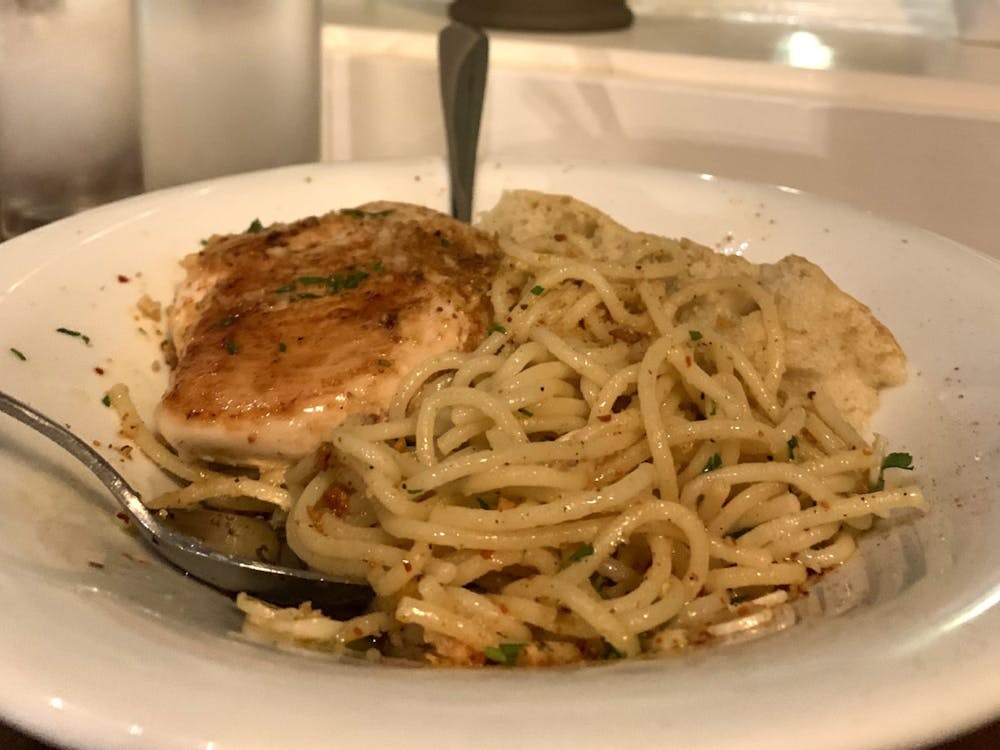 Aglio e Olio pasta topped with parsley and red chili flakes is pictured﻿ March 7, 2023, at Osteria Rago. Pasta is a fairly simple and cheap food option for students. 