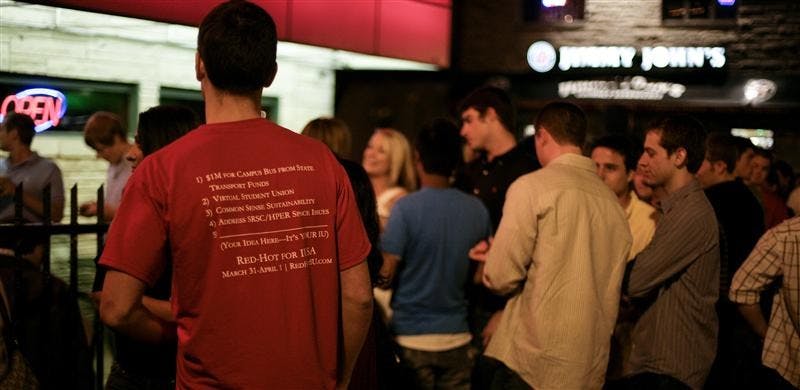 A member of the Red-Hot ticket speaks to locals outside of Kilroy's on Kirkwood early Wednesday morning.  Btown ticket won the election. 