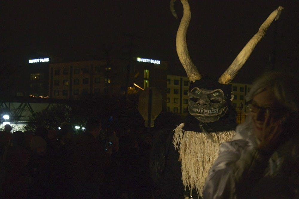 People dress up as demonic followers of Krampus, the "Bad Santa," during the 2014 Krampus parade in downtown Bloomington. The creatures walked down Madison Street and taunted people wearing "Naughty" stickers.